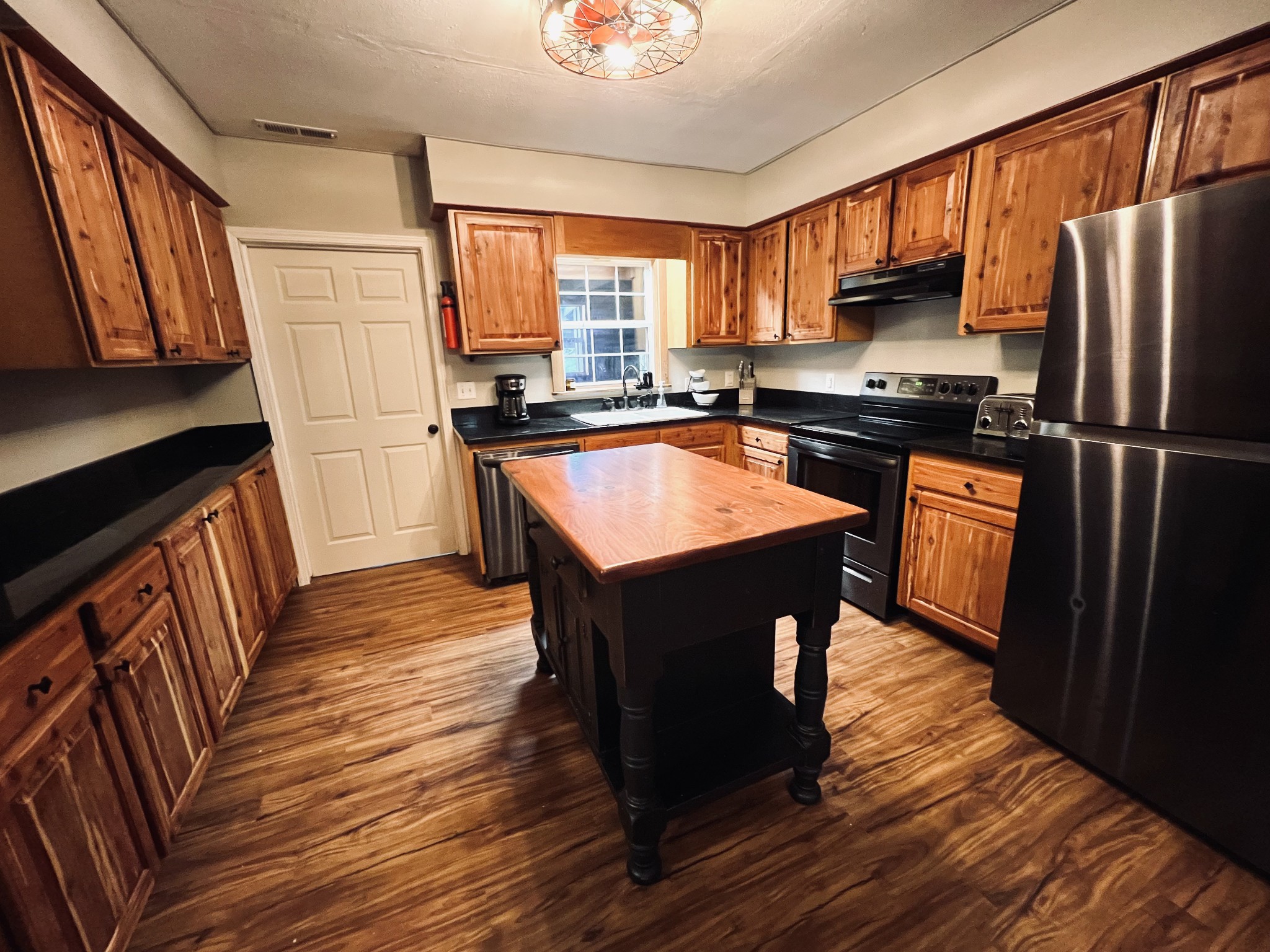 233 Taylor Lake Road Morrison, TN 37357 - Photo 35 of 51 a kitchen with stainless steel appliances granite countertop a refrigerator a stove top oven a sink dishwasher and wooden cabinets with wooden floor