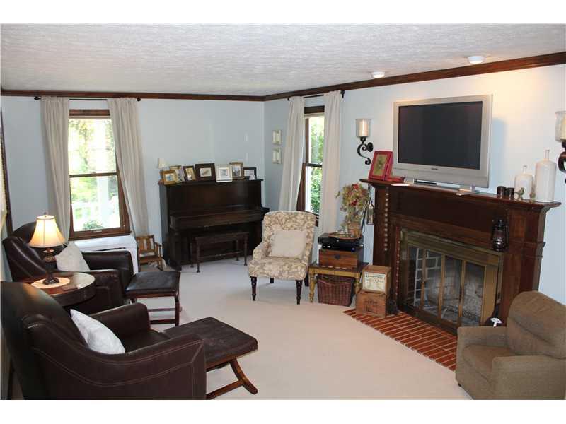 Living Room. The formal living room is light and bright with a log burning fireplace and wood mantel.