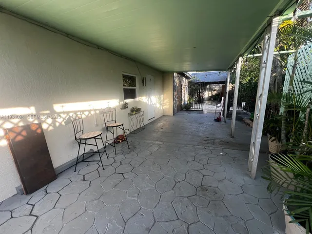 a view of a chairs and table in backyard of a house