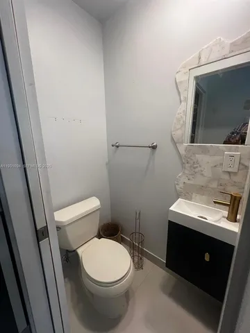 a bathroom with a toilet sink and mirror