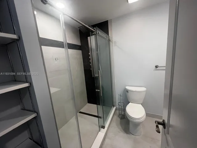 a bathroom with a toilet and a shower