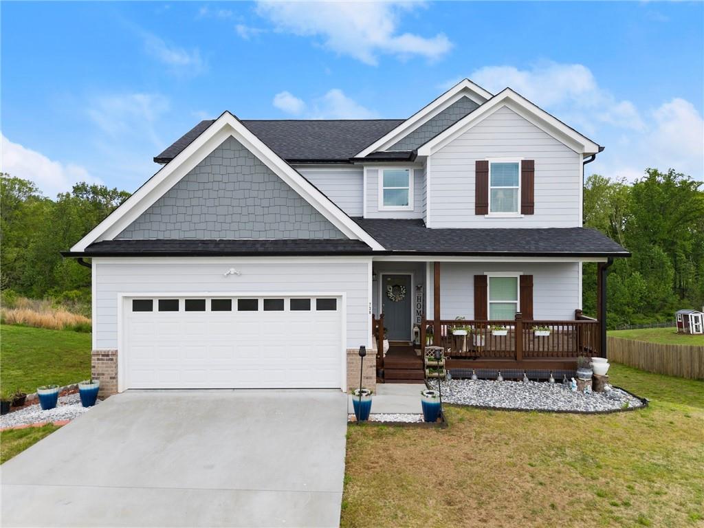 a view of a white house with a yard table and chairs