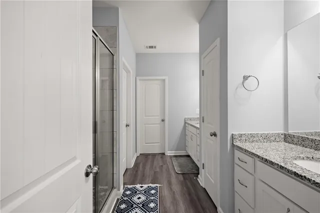 a bathroom with a granite countertop sink and a shower