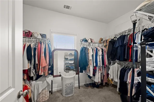 a view of walk in closet with clothes