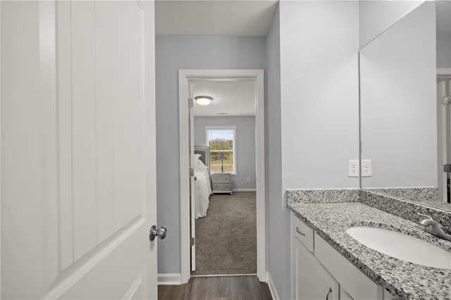 a bathroom with a granite countertop sink and a mirror