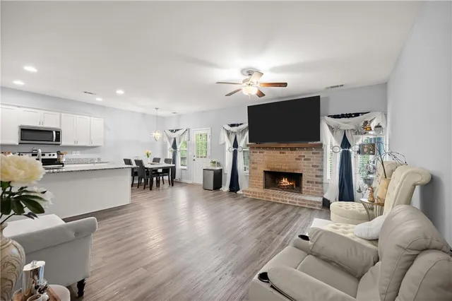 a living room with furniture a fireplace a flat screen tv and view kitchen