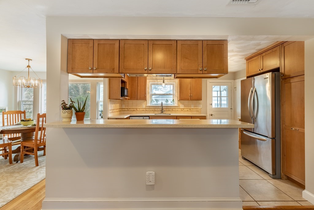 107 Oliver Road Waban, MA 02468 - Photo 11 of 32 a kitchen with a refrigerator and table chair