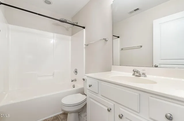 a bathroom with a sink a toilet and a large mirror