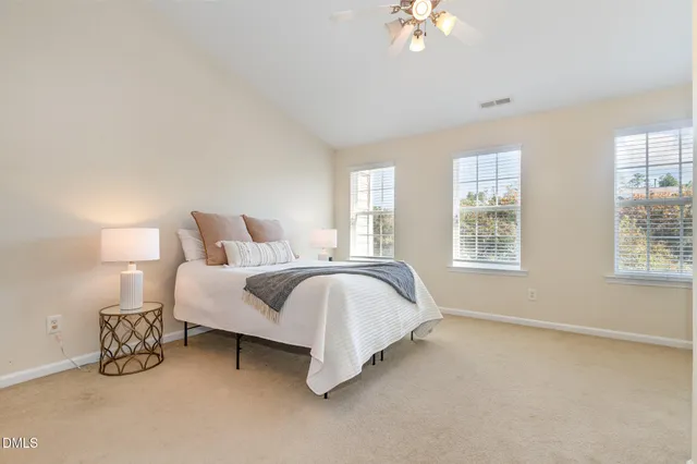 a spacious bedroom with a bed and a chandelier