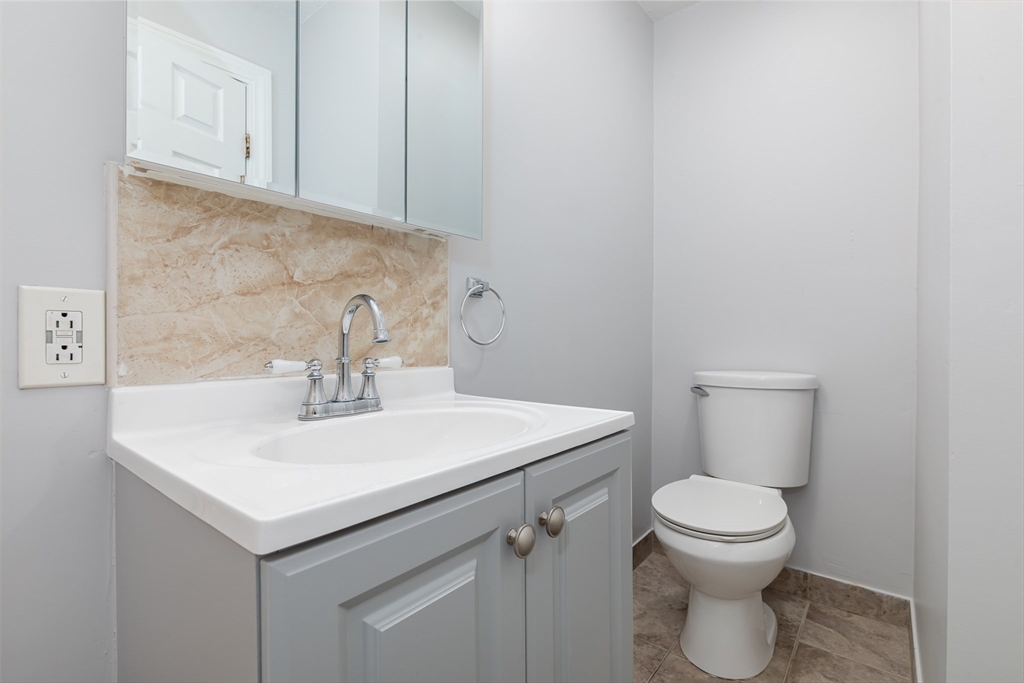 185 Lewis Street, Unit 4 Lynn, MA 01902 - Photo 14 of 20 a bathroom with a sink a toilet and a mirror