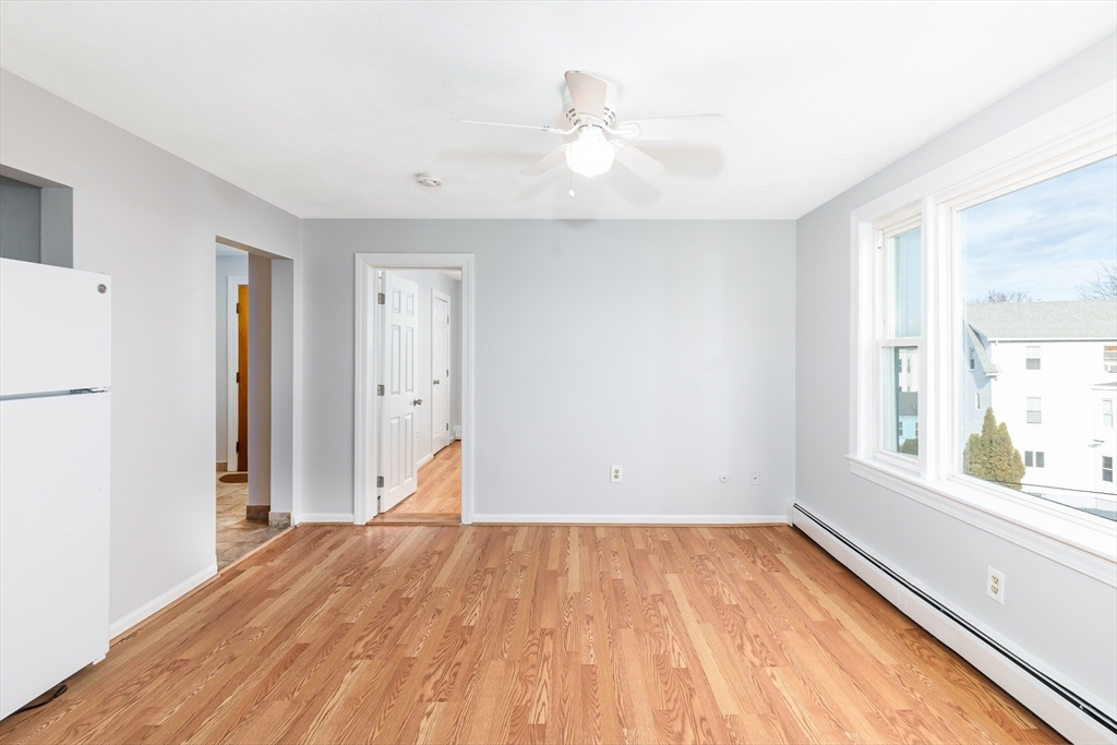 185 Lewis Street, Unit 4 Lynn, MA 01902 - Photo 6 of 20 a view of empty room with wooden floor and fan