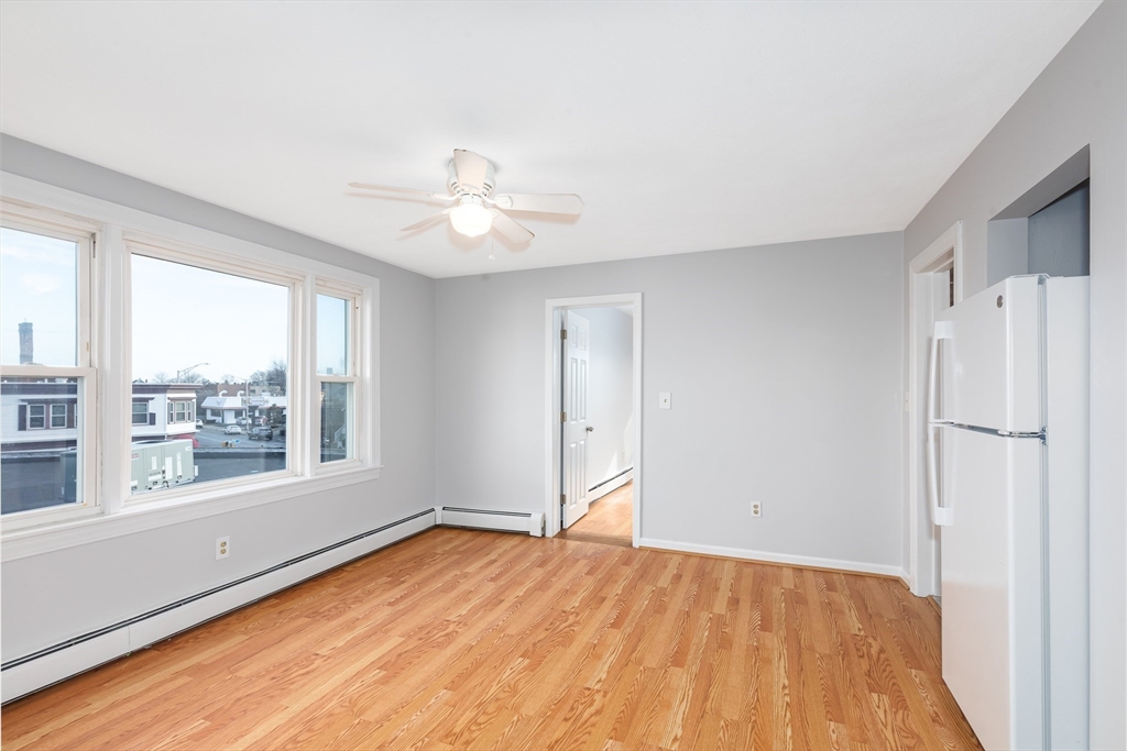 185 Lewis Street, Unit 4 Lynn, MA 01902 - Photo 7 of 20 a view of an empty room with a window and wooden floor