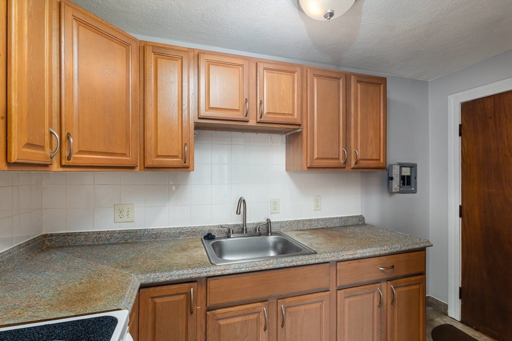 185 Lewis Street, Unit 4 Lynn, MA 01902 - Photo 10 of 20 a kitchen with stainless steel appliances granite countertop a sink a refrigerator and cabinets