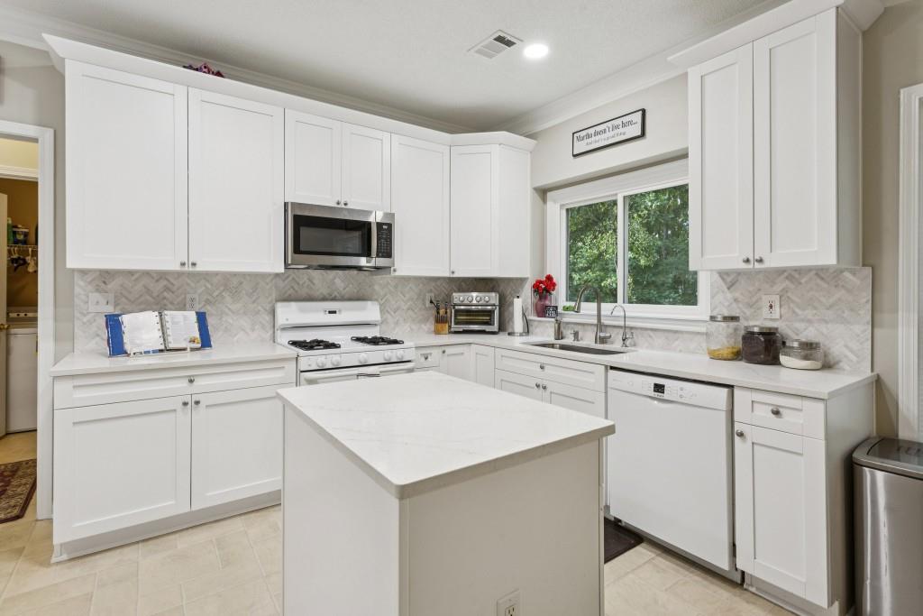 4815 Tanners Spring Drive Alpharetta, GA 30022 - Photo 15 of 45 a kitchen with cabinets appliances a sink and a window