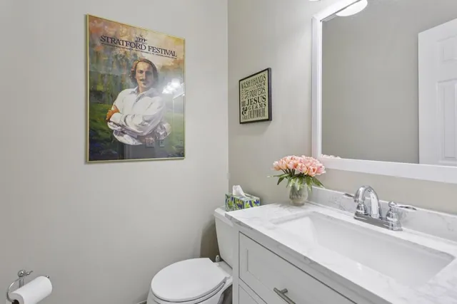 a bathroom with a toilet sink vanity and mirror
