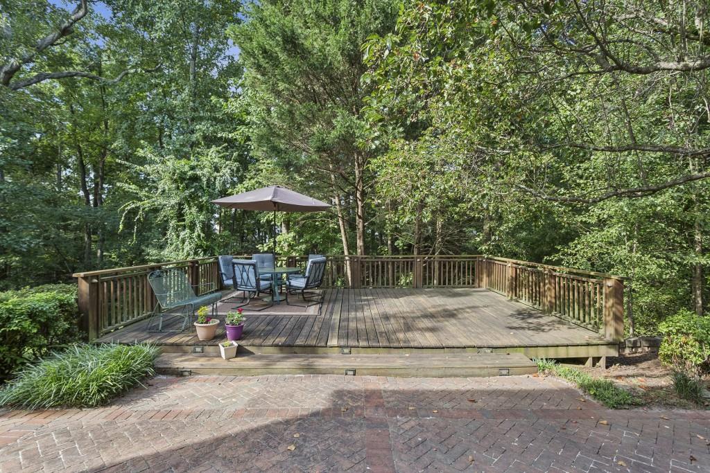 4815 Tanners Spring Drive Alpharetta, GA 30022 - Photo 33 of 45 a backyard of a house with table and chairs under an umbrella