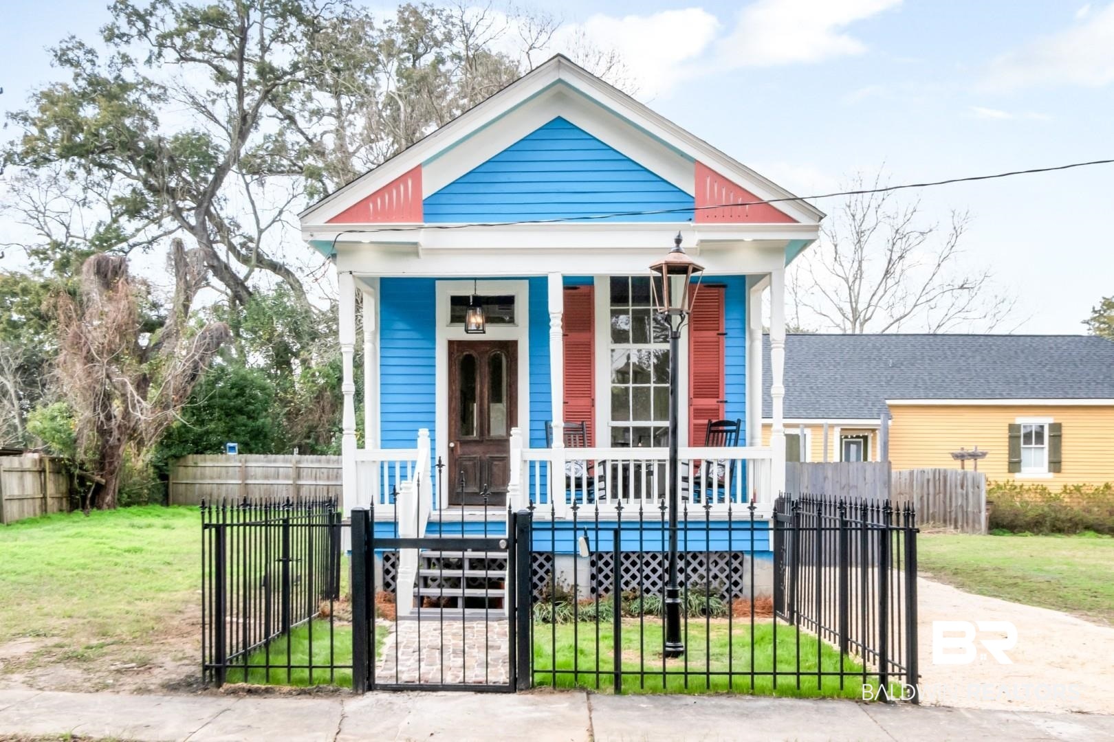 352 Marine Street Mobile, AL 36604 - Photo 1 of 20 Shotgun-style home featuring a porch, a fenced front yard, and a gate