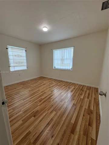 a view of a room with wooden floor and window
