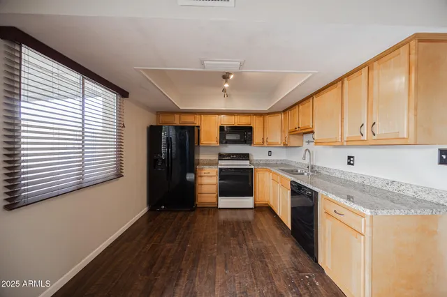 a view of kitchen with stainless steel appliances refrigerator stove and wooden cabinets