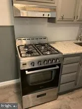 a stove top oven sitting inside of a kitchen