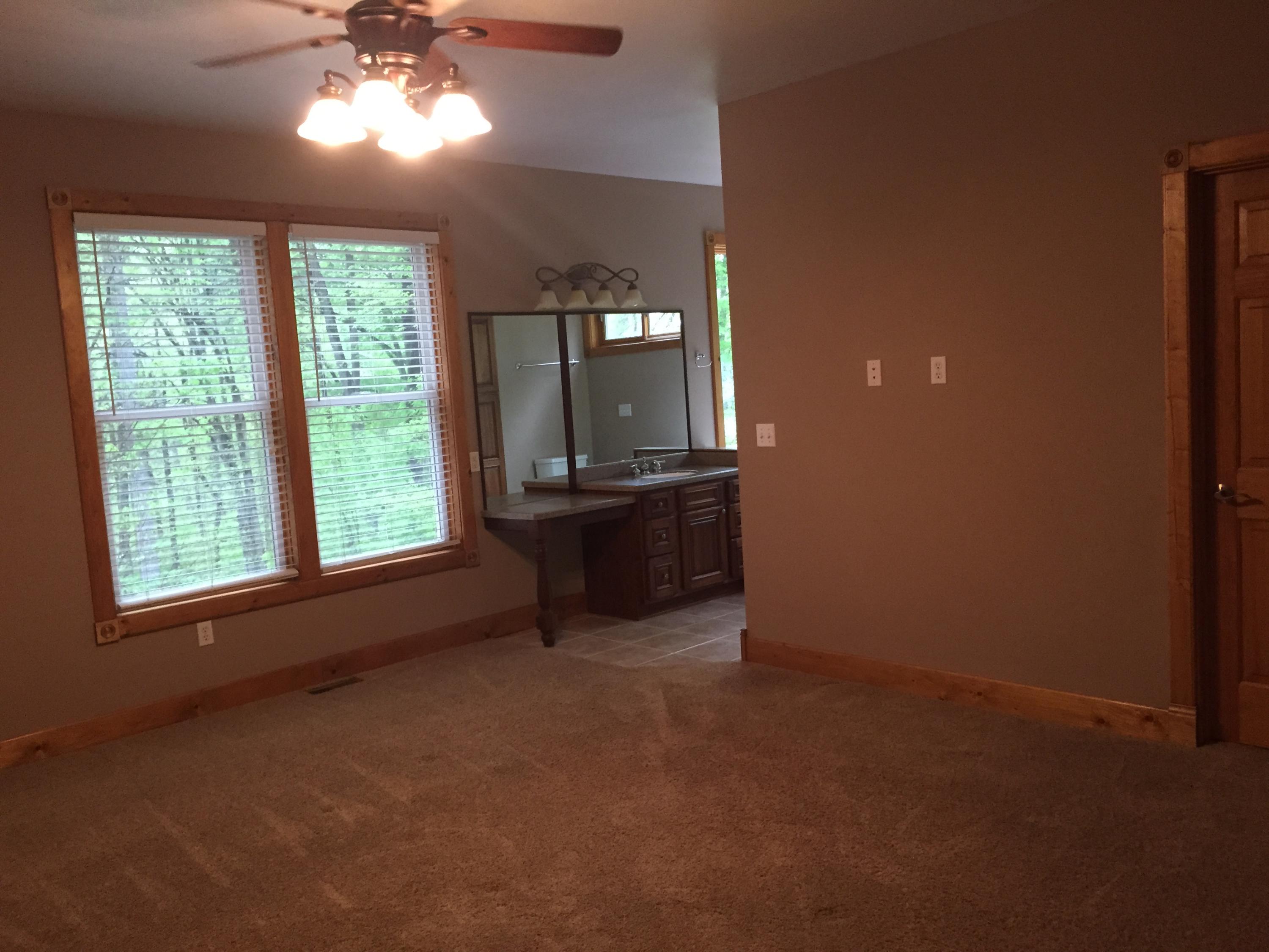 4560 White House Road Moneta, VA 24121 - Photo 14 of 17 an empty room with windows and chandelier fan
