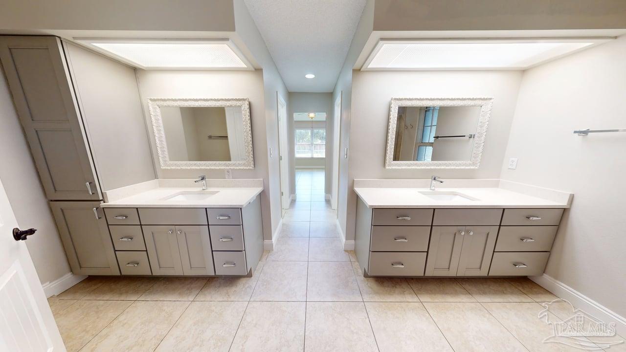 10111 Bristol Park Road Cantonment, FL 32533 - Photo 21 of 72 a bathroom with a double vanity sink mirror and bathtub