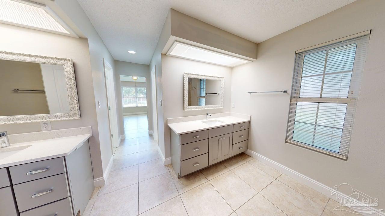 10111 Bristol Park Road Cantonment, FL 32533 - Photo 22 of 72 a spacious bathroom with a double vanity sink a mirror and a bathtub