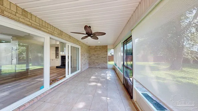 a view of an empty room with wooden floor and windows
