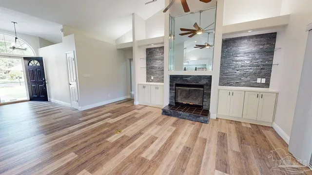 a view of a livingroom with wooden floor and a fireplace