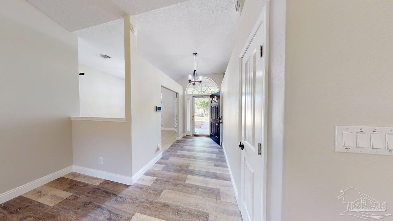 10111 Bristol Park Road Cantonment, FL 32533 - Photo 43 of 72 a view of a hallway with wooden floor and entryway