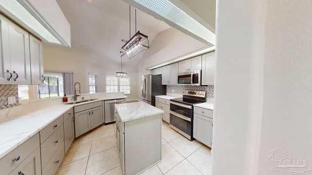 a view of an empty room with wooden floor and windows