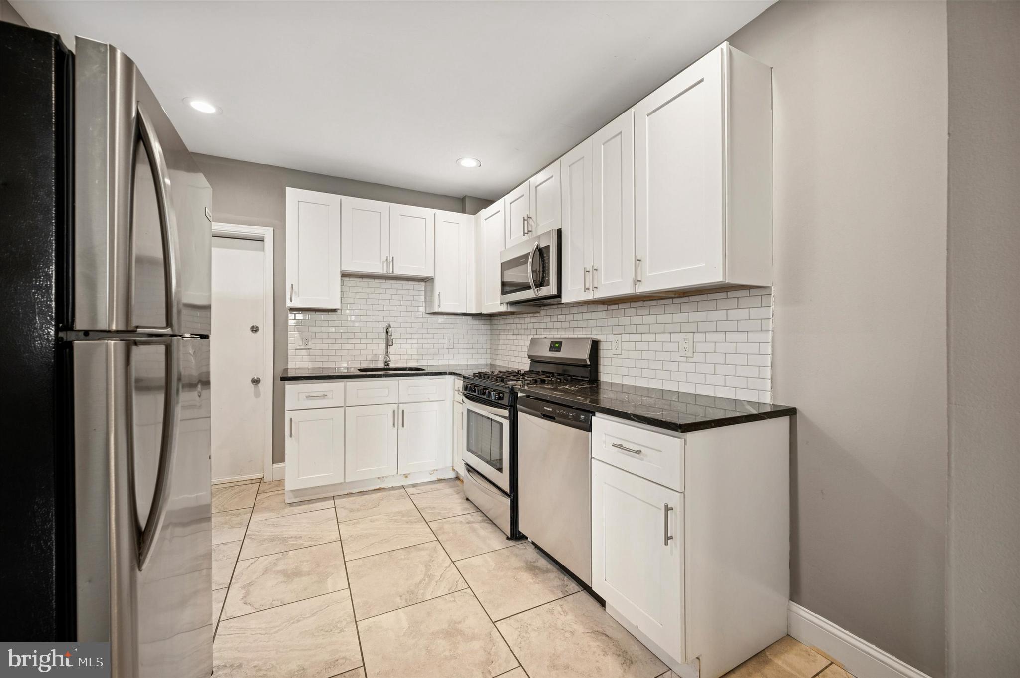 2147 North Marston Street Philadelphia, PA 19121 - Photo 3 of 15 a kitchen with stainless steel appliances granite countertop a refrigerator sink and white cabinets