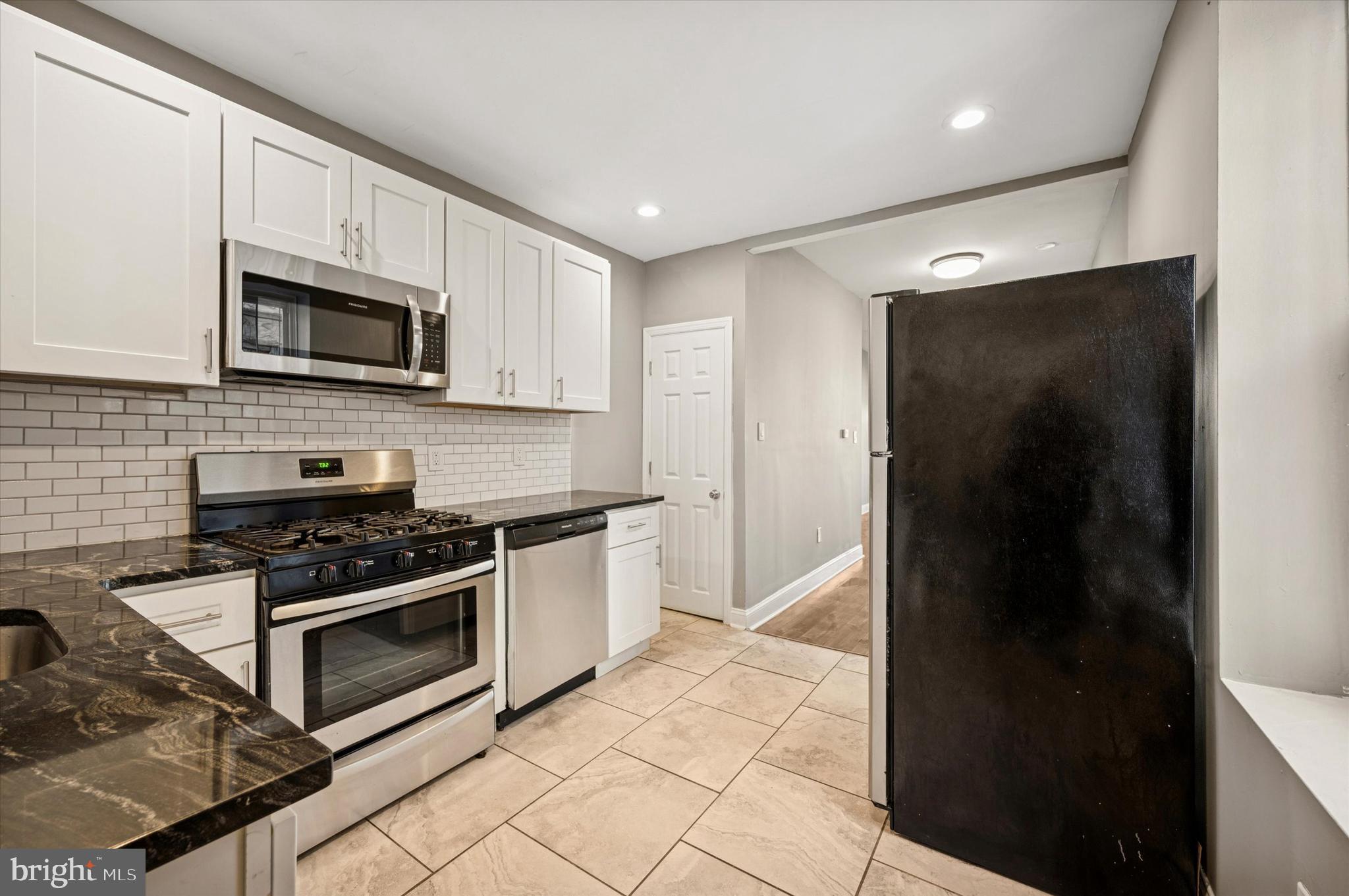 2147 North Marston Street Philadelphia, PA 19121 - Photo 4 of 15 a kitchen with stainless steel appliances granite countertop a stove a refrigerator and a microwave