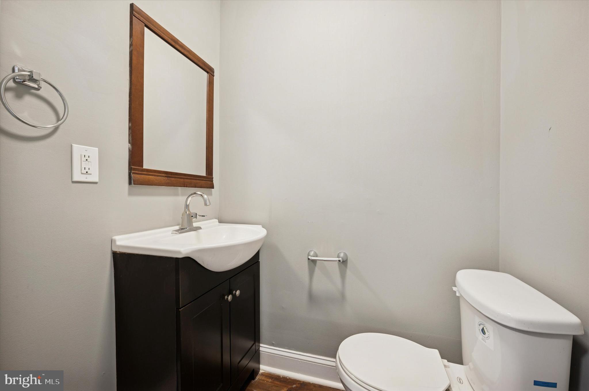 2147 North Marston Street Philadelphia, PA 19121 - Photo 9 of 15 a bathroom with a toilet a sink a mirror and vanity