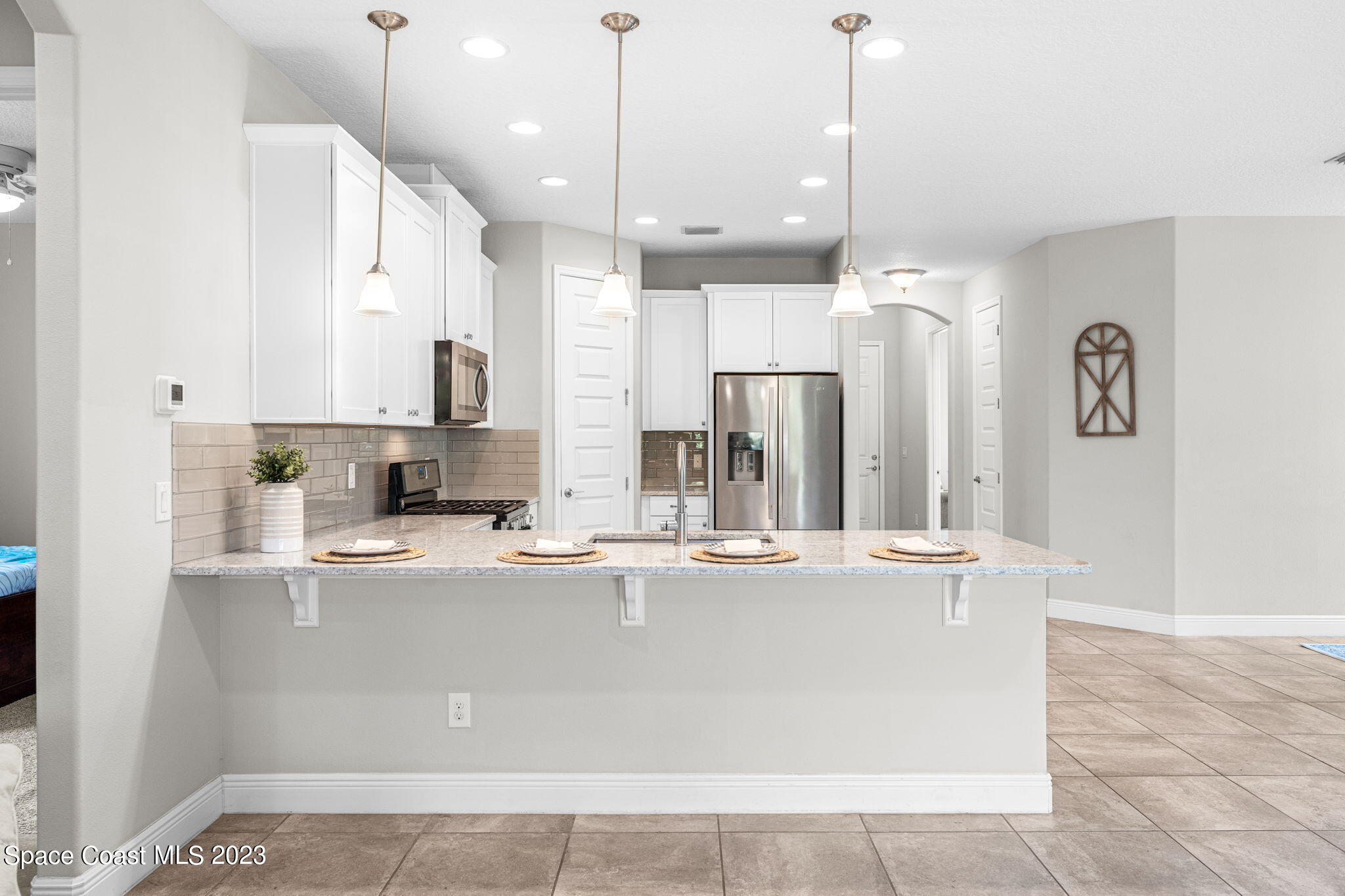 3640 Stabane Place Melbourne, FL 32940 - Photo 33 of 85 a large kitchen with kitchen island a large counter top stainless steel appliances and cabinets