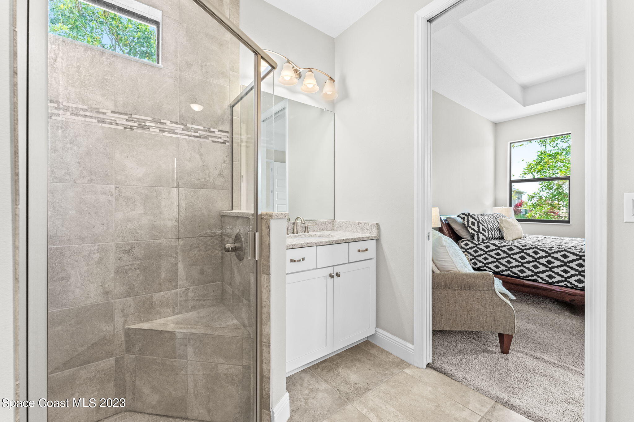 3640 Stabane Place Melbourne, FL 32940 - Photo 36 of 85 a bathroom with a granite countertop sink a mirror and a shower