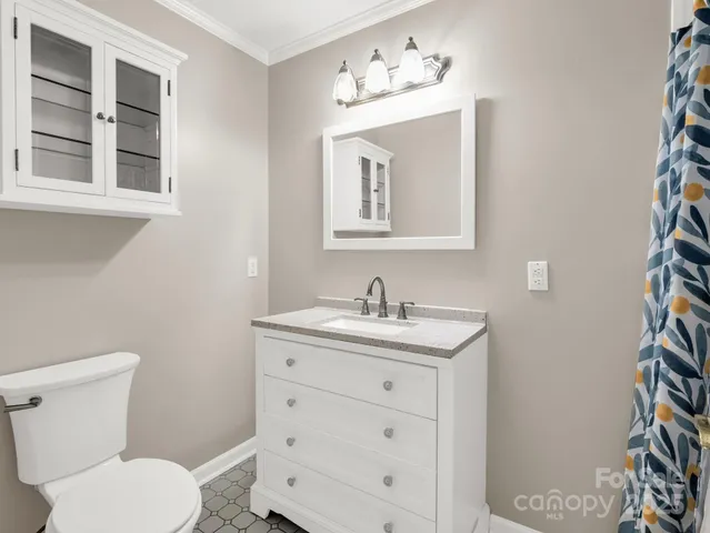 a bathroom with a toilet a sink and mirror