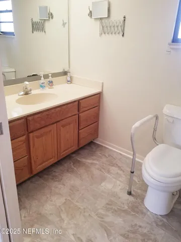 a bathroom with a granite countertop toilet and a sink