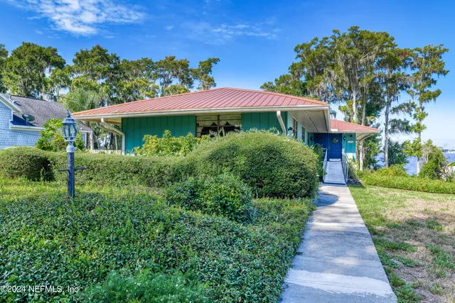 a front view of a house with yard and green space