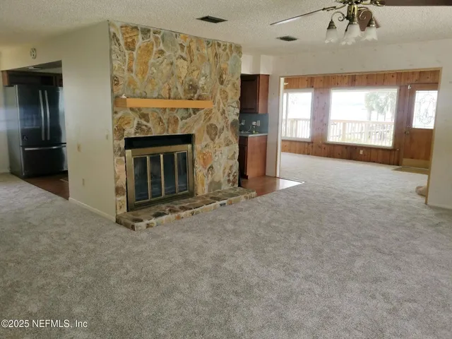 a view of an empty room with a fireplace and a window