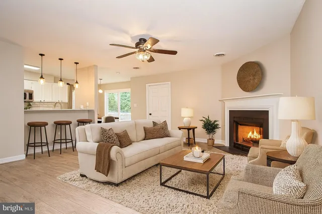 a living room with furniture a fireplace and a chandelier
