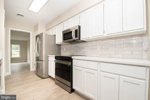 a kitchen with stainless steel appliances granite countertop a sink a stove a microwave and cabinets