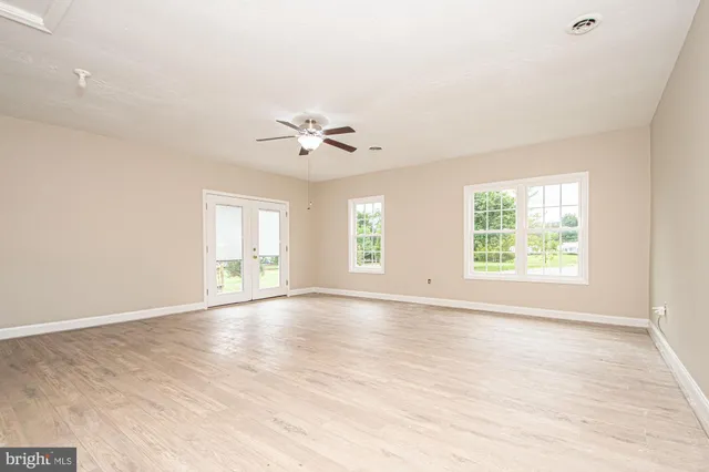 an empty room with wooden floor and window