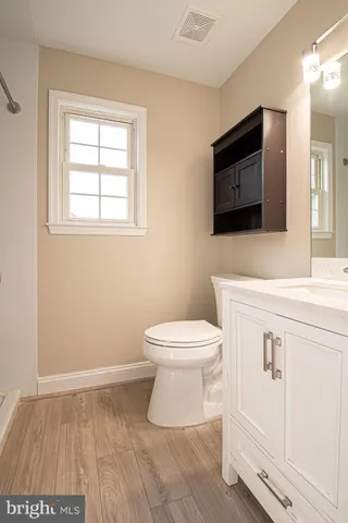 a bathroom with a toilet sink and mirror