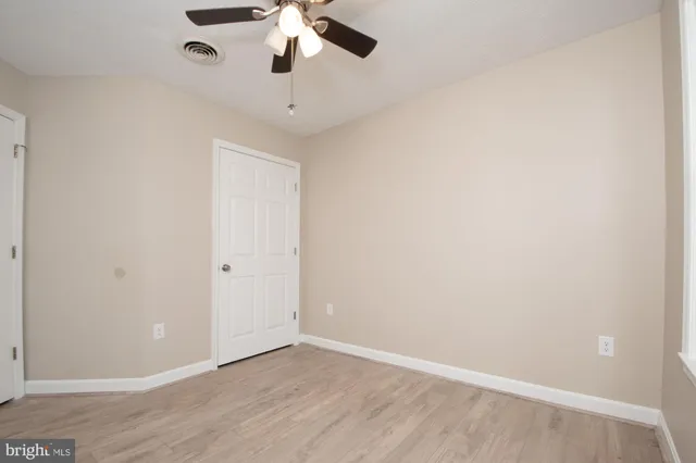 an empty room with a chandelier fan and a ceiling fan