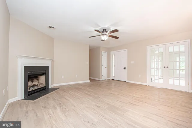 a view of empty room with a fireplace and fan