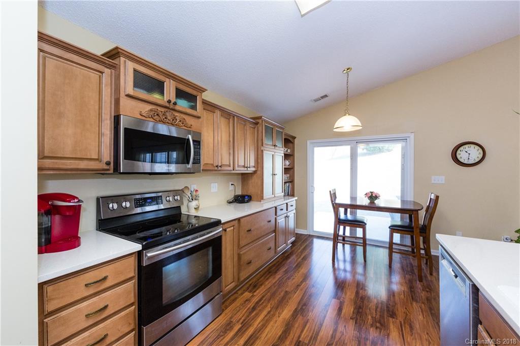 236 Grayland Road Mooresville, NC 28115 - Photo 12 of 27 a kitchen with stainless steel appliances a dining table chairs stove microwave and cabinets