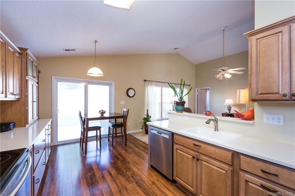 236 Grayland Road Mooresville, NC 28115 - Photo 13 of 27 a kitchen with stainless steel appliances a dining table chairs sink and wooden floor