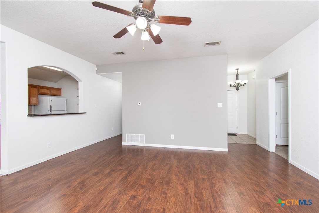 568 Morgan's Point Road Belton, TX 76513 - Photo 4 of 20 an empty room with wooden floor chandelier fan and windows