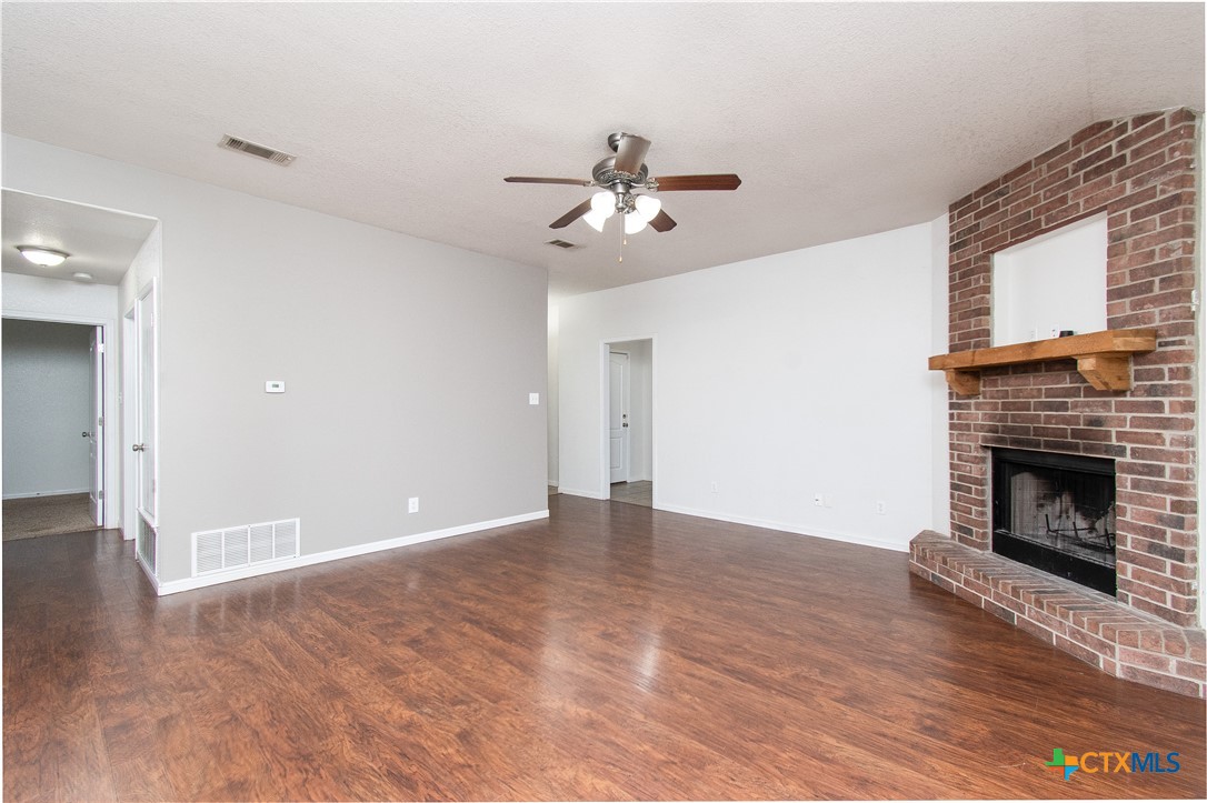 568 Morgan's Point Road Belton, TX 76513 - Photo 5 of 20 a view of empty room with wooden floor and a fireplace